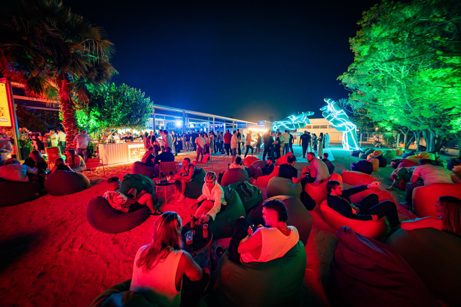 An open-air Doers evening after dark, members gathered under the lights