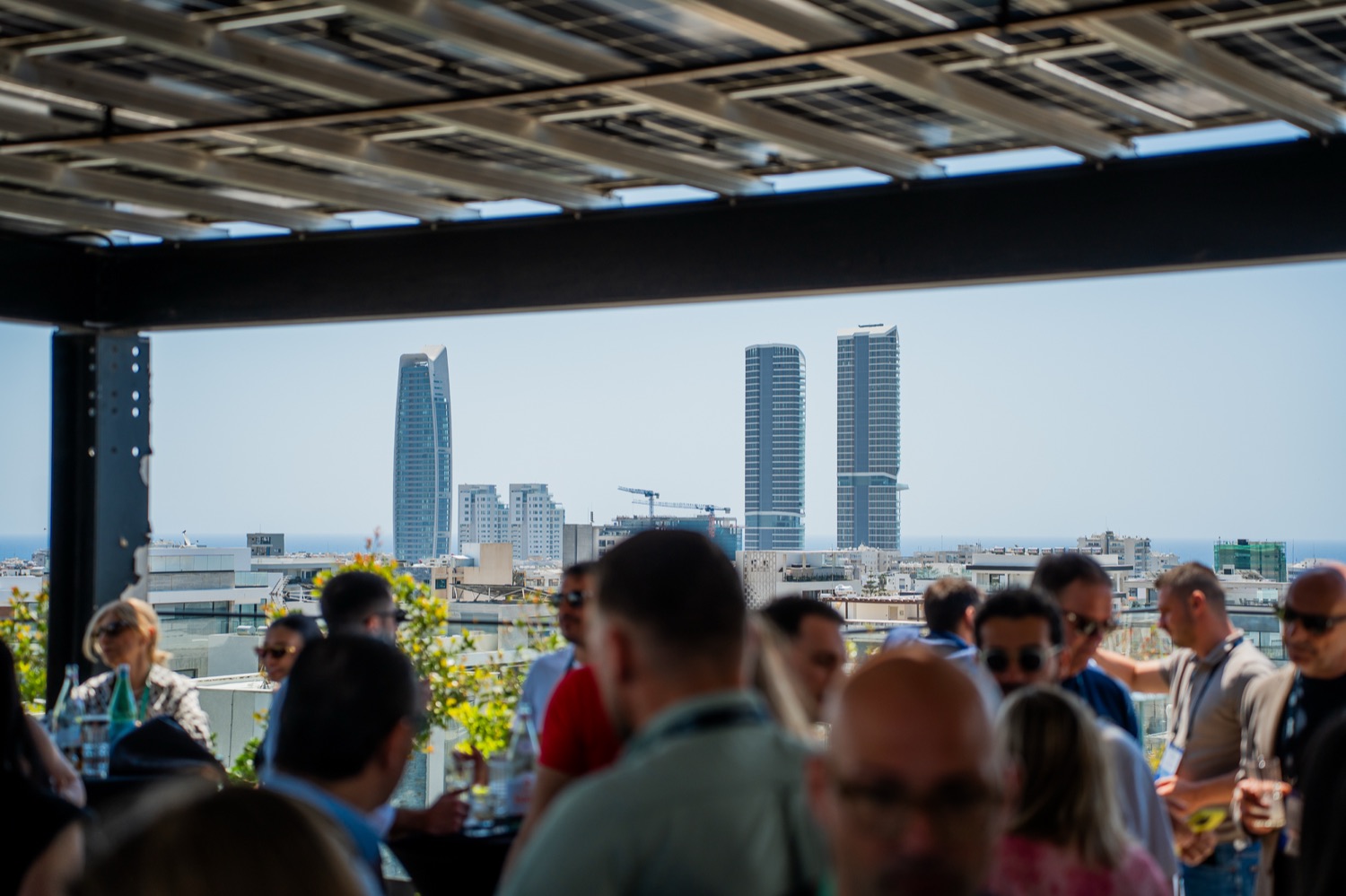Members talking on a rooftop above the city skyline